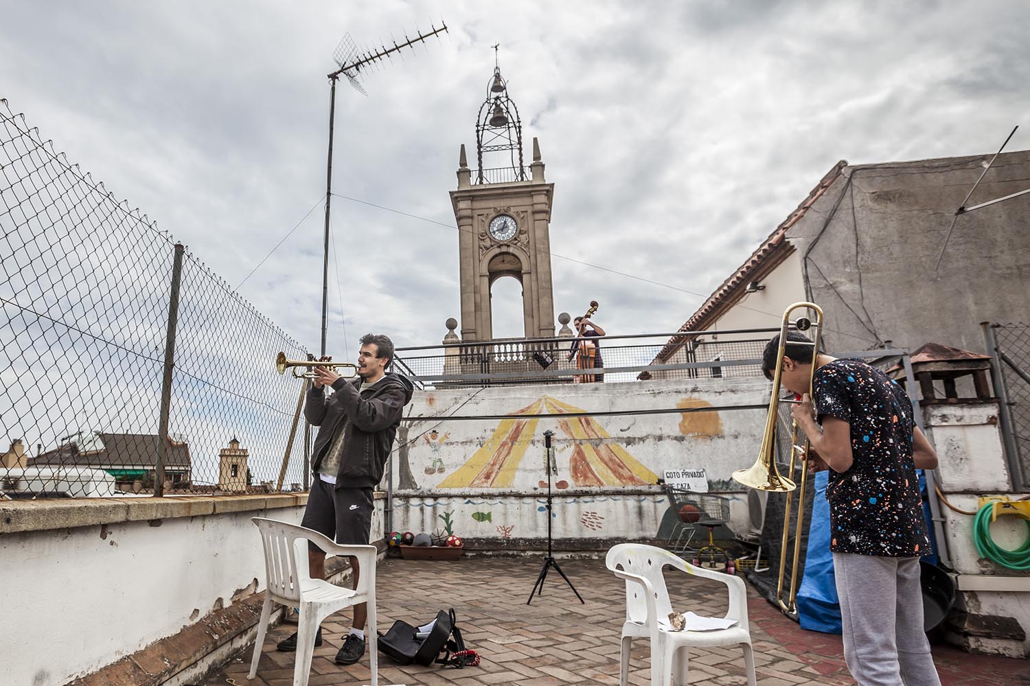 OTROS ESCENARIOS POSIBLES28/03/2020VECINOS EN HORTA TOCAN A LAS 13H CON UNA TROMPETA Y UN TROMBON DOS HERMANOS Y EL VECINO DE ARRIBA TOCA EL CONTRABAJOFOTO MARTI FRADERA