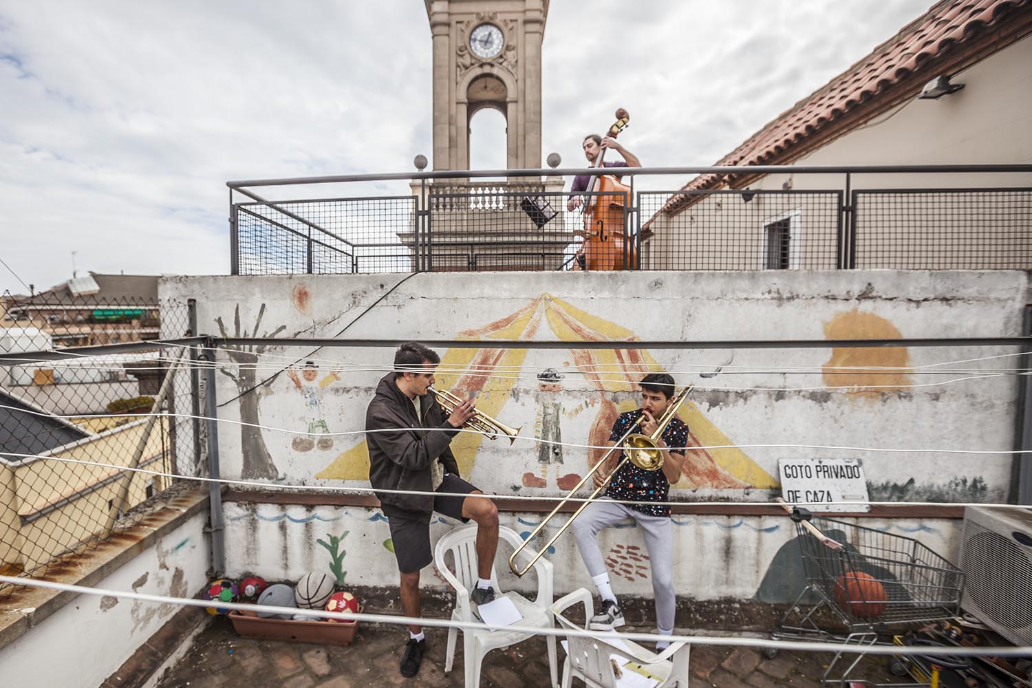 OTROS ESCENARIOS POSIBLES28/03/2020VECINOS EN HORTA TOCAN A LAS 13H CON UNA TROMPETA Y UN TROMBON DOS HERMANOS Y EL VECINO DE ARRIBA TOCA EL CONTRABAJOFOTO MARTI FRADERA