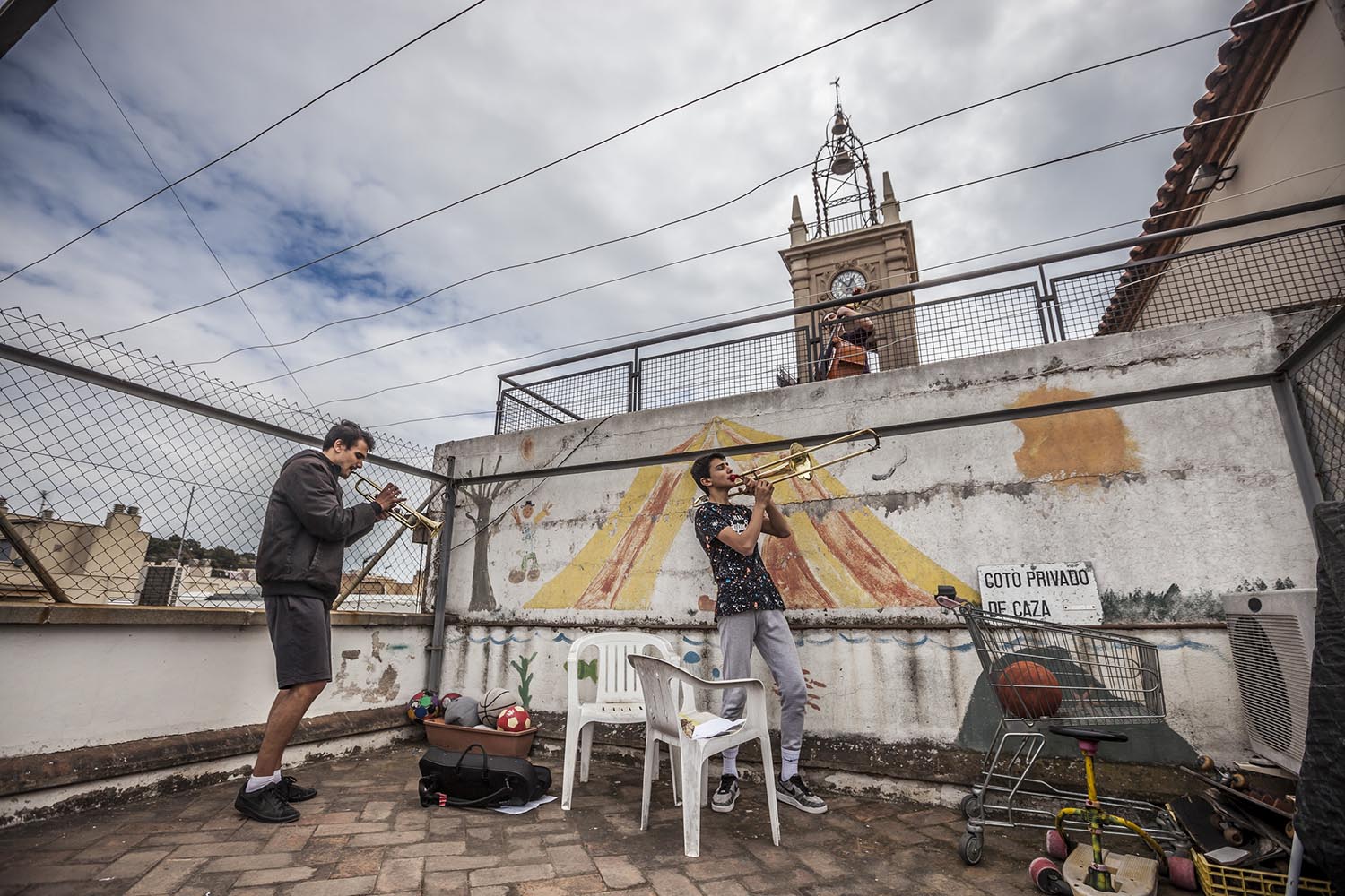 OTROS ESCENARIOS POSIBLES28/03/2020VECINOS EN HORTA TOCAN A LAS 13H CON UNA TROMPETA Y UN TROMBON DOS HERMANOS Y EL VECINO DE ARRIBA TOCA EL CONTRABAJOFOTO MARTI FRADERA